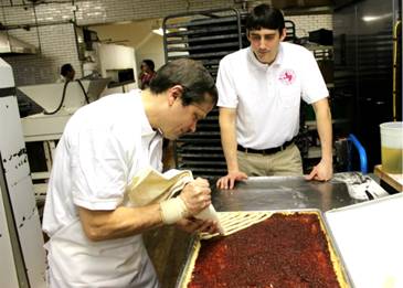 Congressman Quigley  learns the proper technique for creating the perfect raspberry linzer tart from Dinkel family member Luke Karl.